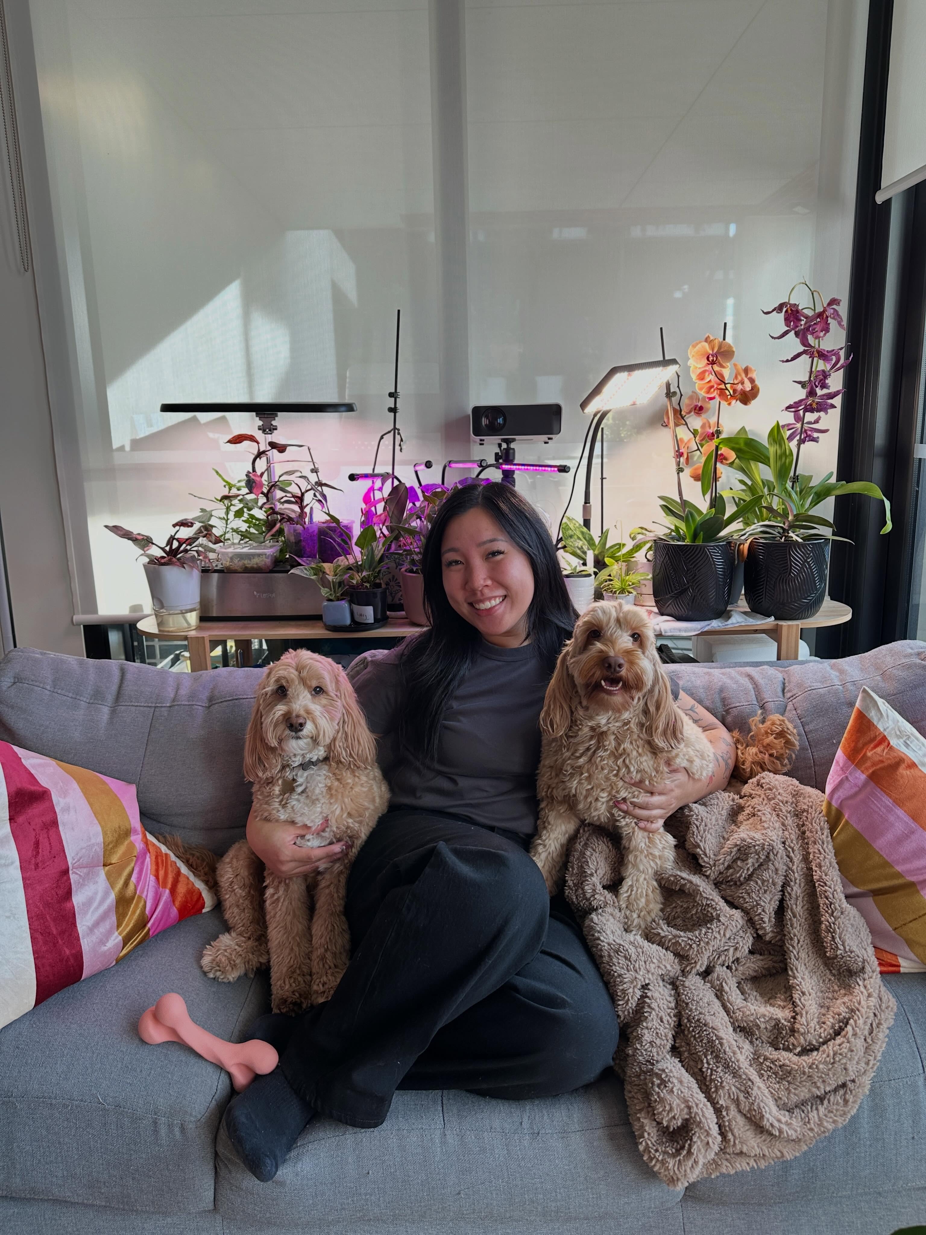 Alexandra, founder of Petals & Paws Melbourne, with two Oodle companion dogs in a calm home setting